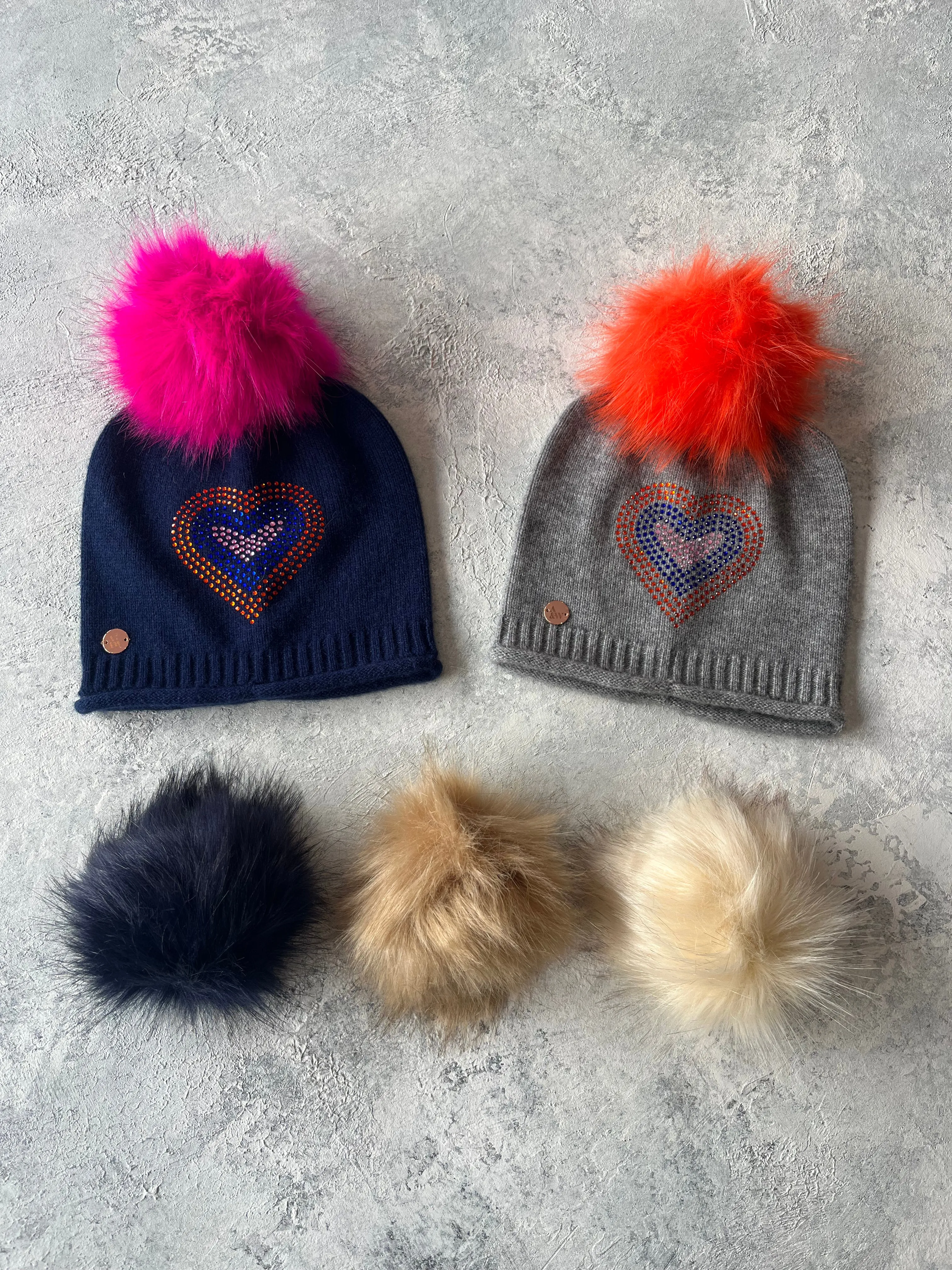 Grey cashmere plain knit beanie with heart embellishment & faux fur pom